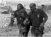 historic photo of a rescuer leading civilians away from the World Trade Center collapse on 9/11/2001